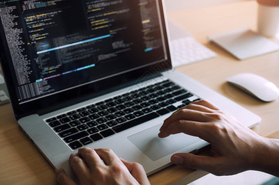 軟件開發(fā)者的近視正在認真分析計算機屏幕上的數(shù)據(jù)